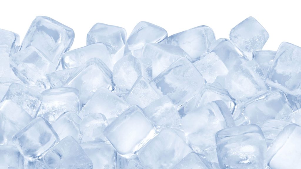 A pile of clear ice cubes stacked closely together against a white background—reminding us that chewing hard foods that damage teeth, like ice, can easily lead to a cracked tooth.