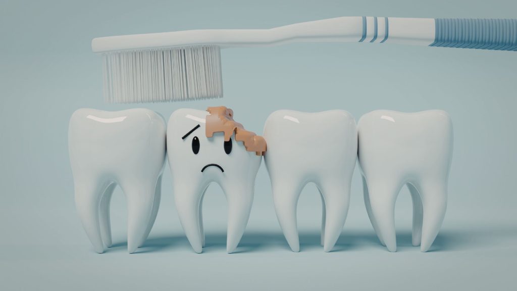 A toothbrush cleaning four teeth, with one tooth showing a sad face and a visible brown cavity or decay on its surface.